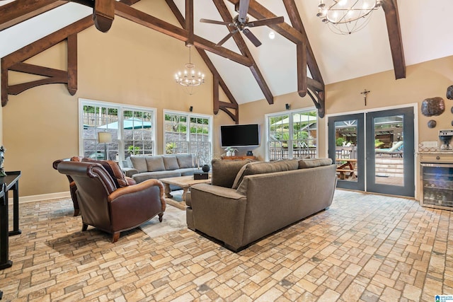 living room with beam ceiling, high vaulted ceiling, beverage cooler, baseboards, and ceiling fan with notable chandelier