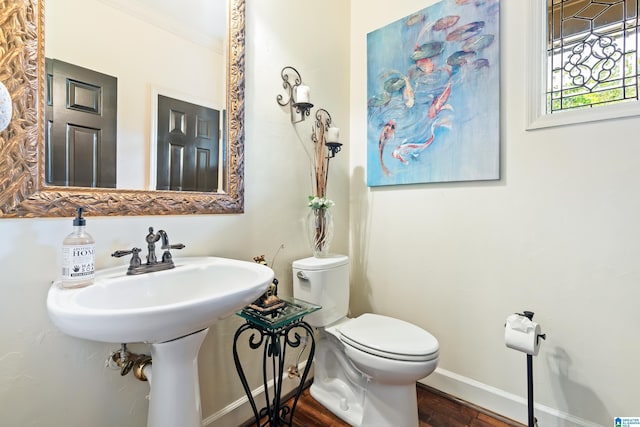 bathroom with wood finished floors, toilet, and baseboards