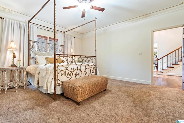 carpeted bedroom with baseboards, a ceiling fan, and crown molding