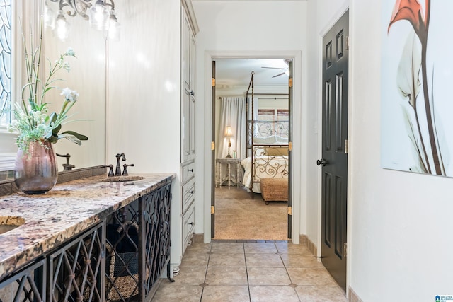 ensuite bathroom with tile patterned flooring, vanity, and ensuite bath