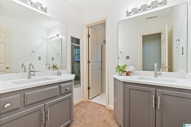 bathroom with a stall shower, visible vents, two vanities, and a sink