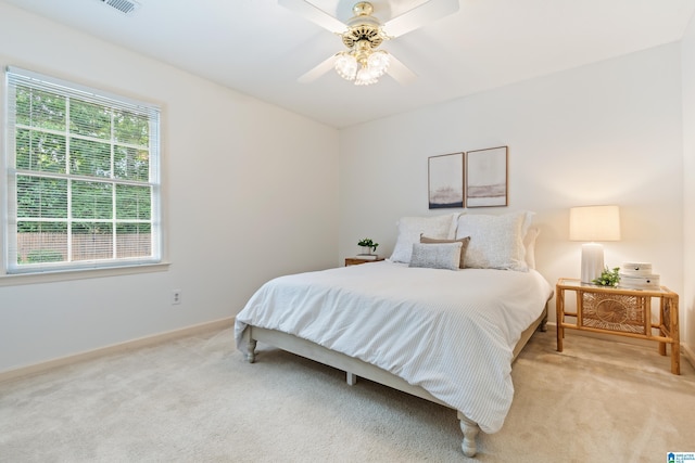 bedroom with baseboards, a ceiling fan, and light colored carpet