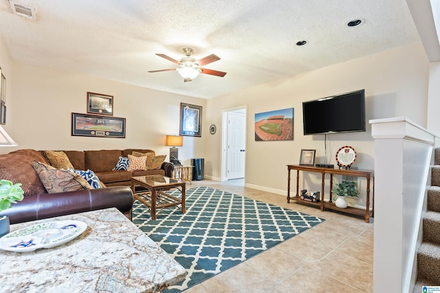 living area with visible vents, stairway, ceiling fan, a textured ceiling, and tile patterned flooring