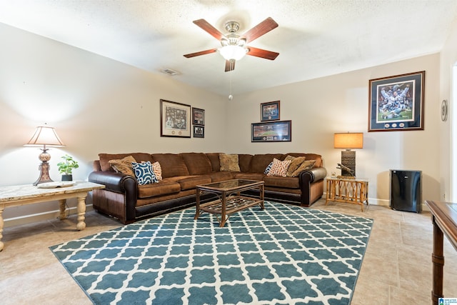 living room featuring a ceiling fan, tile patterned flooring, visible vents, and a textured ceiling