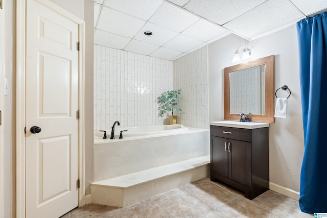 full bathroom featuring a garden tub, a paneled ceiling, vanity, baseboards, and tile patterned floors