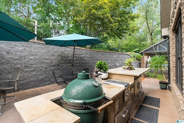 view of patio with fence and area for grilling