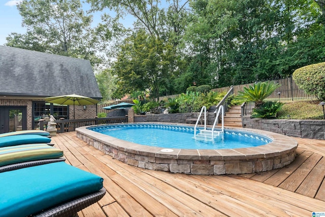 view of swimming pool with fence, a wooden deck, and stairs