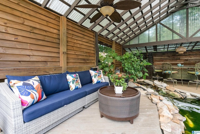 sunroom with a ceiling fan and vaulted ceiling