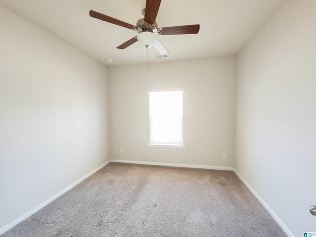 carpeted empty room with a ceiling fan, visible vents, and baseboards