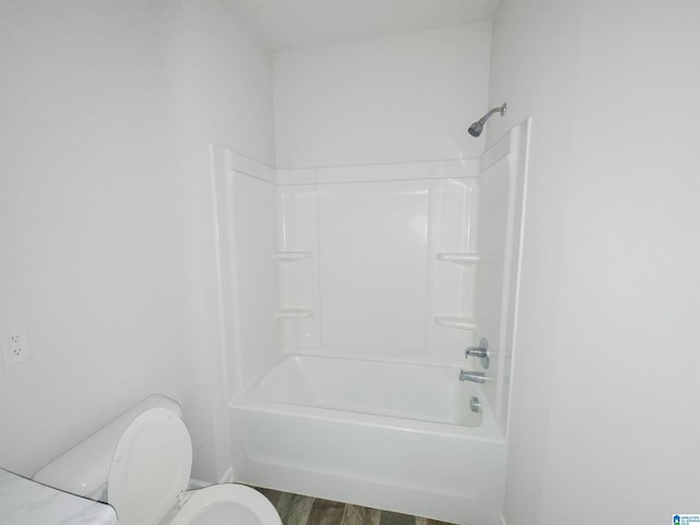 full bathroom with shower / washtub combination, toilet, and wood finished floors