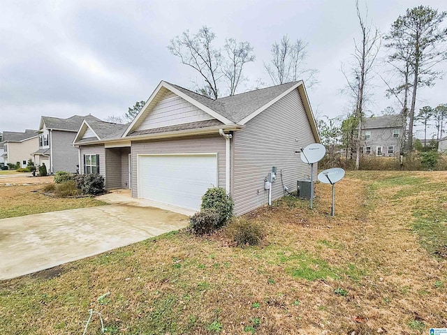 view of front of property featuring an attached garage, concrete driveway, and a front yard