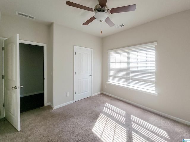 unfurnished bedroom featuring carpet flooring, visible vents, and baseboards