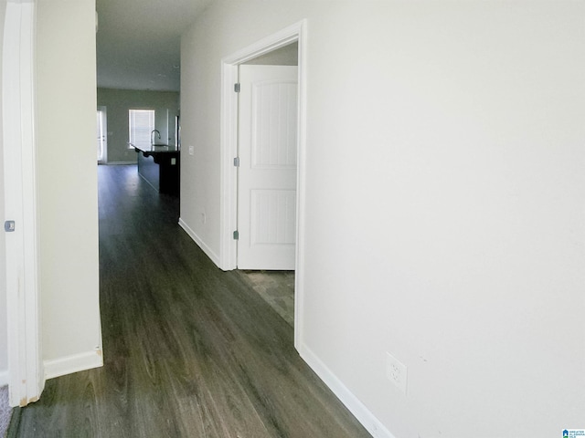 hall with dark wood-style floors and baseboards