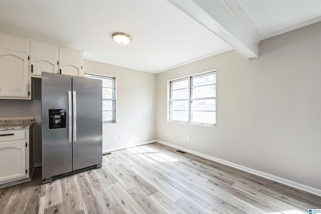 kitchen with light wood-style flooring, baseboards, stainless steel refrigerator with ice dispenser, and crown molding