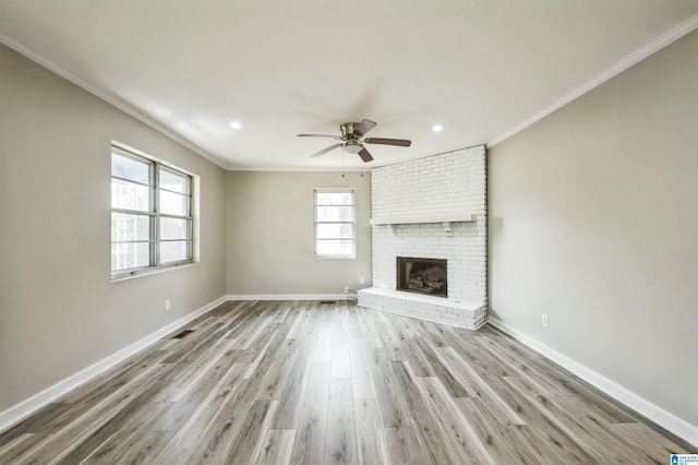 unfurnished living room with baseboards, crown molding, and light wood finished floors