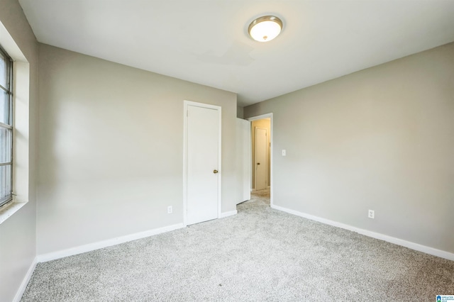 spare room featuring carpet floors and baseboards