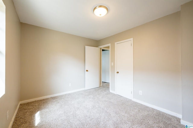 carpeted empty room with baseboards