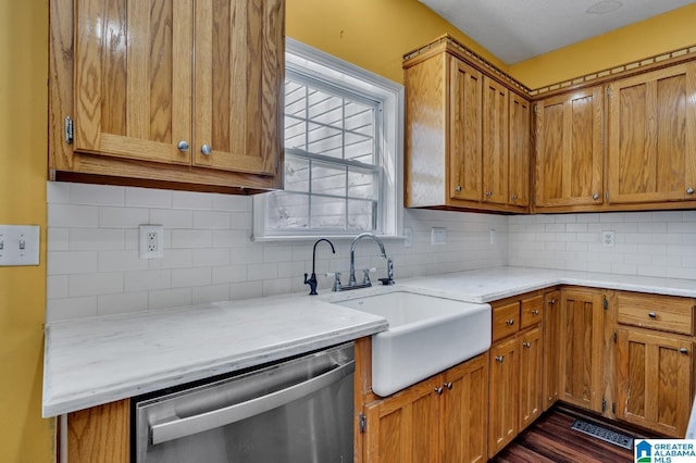 kitchen with light countertops, a sink, backsplash, and stainless steel dishwasher