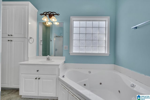 full bath featuring a jetted tub, a shower stall, and vanity