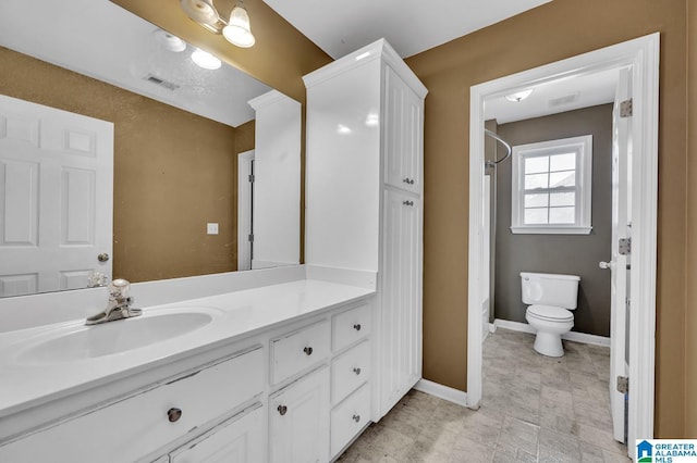 bathroom with toilet, vanity, visible vents, and baseboards