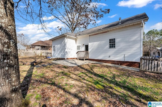 rear view of property featuring a patio area and fence