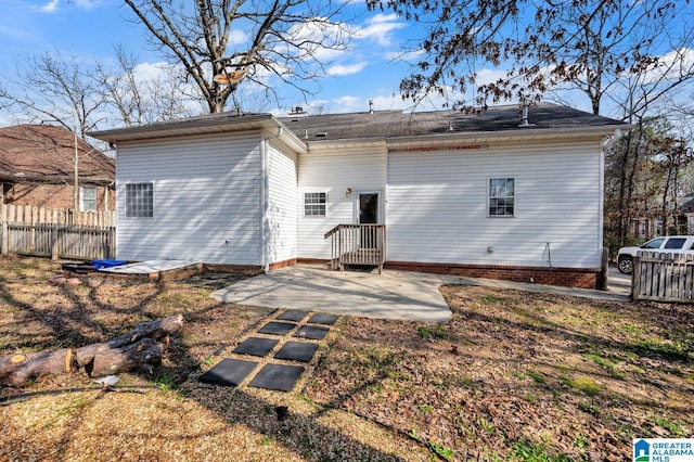 rear view of property featuring a patio area and fence