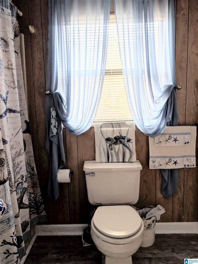 full bath featuring curtained shower, baseboards, and toilet