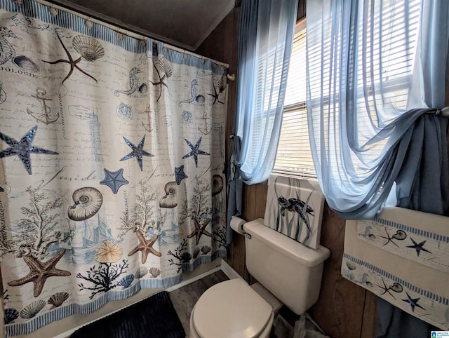 bathroom featuring a shower with shower curtain, toilet, and wood finished floors