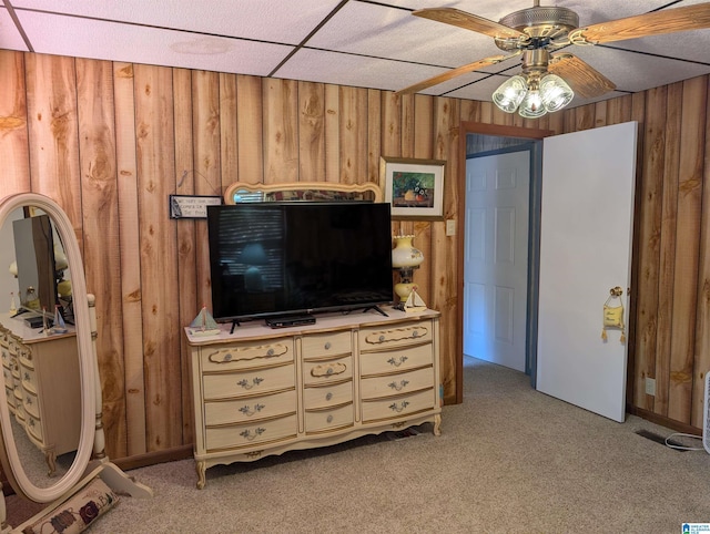 bedroom featuring light carpet and wood walls