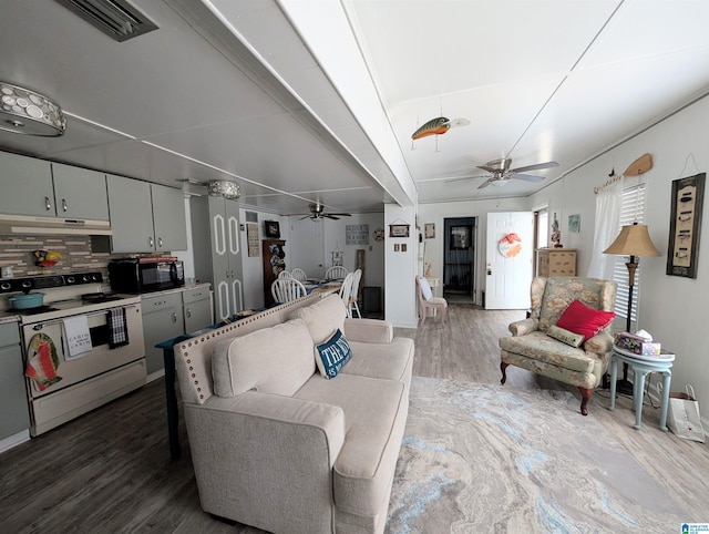 living area featuring visible vents, ceiling fan, and wood finished floors