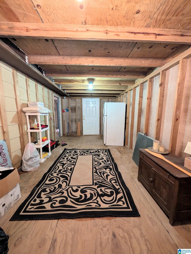 unfinished basement featuring freestanding refrigerator