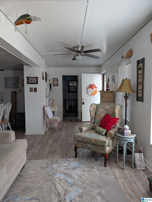 living area featuring a ceiling fan and wood finished floors