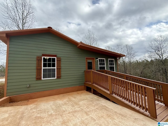 view of side of property with a patio area and a wooden deck