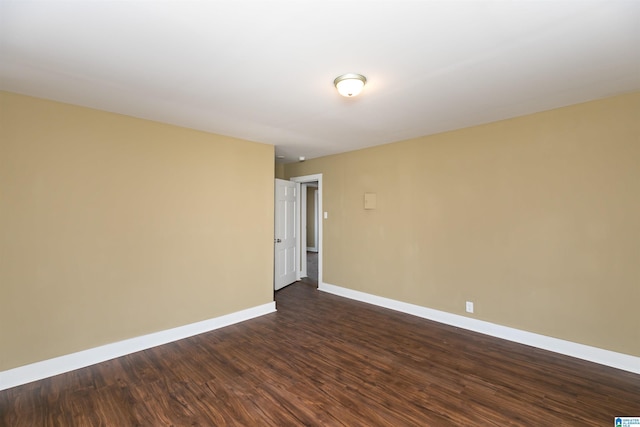 empty room with dark wood-style floors and baseboards