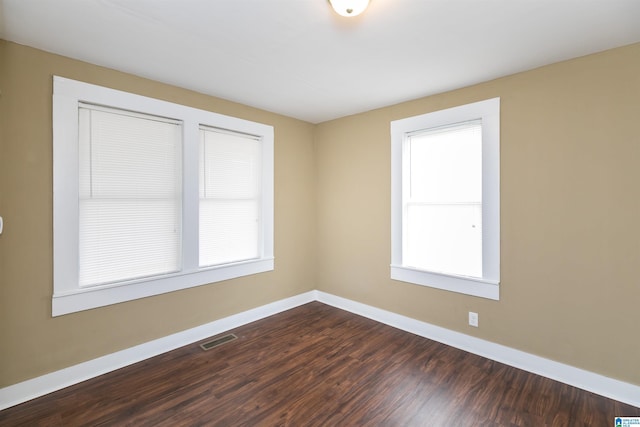 unfurnished room featuring visible vents, baseboards, and a wealth of natural light