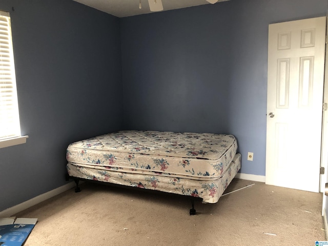 carpeted bedroom with ceiling fan and baseboards