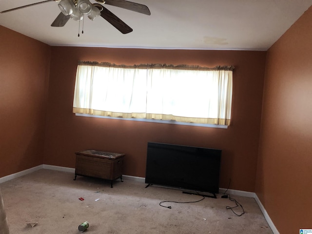 carpeted empty room with a healthy amount of sunlight, ceiling fan, and baseboards