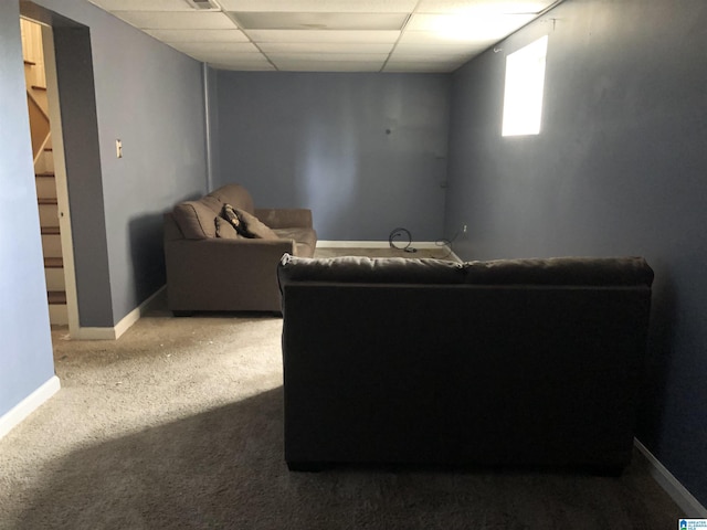 carpeted living area with visible vents, baseboards, and a drop ceiling