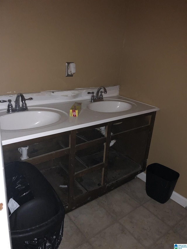 bathroom featuring tile patterned flooring, a sink, and double vanity