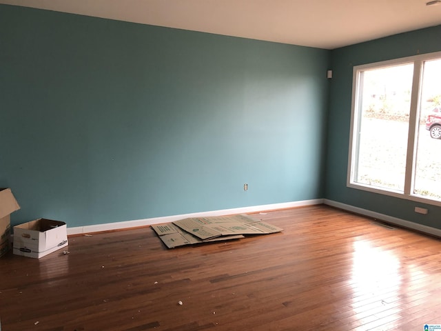 unfurnished room with wood-type flooring and baseboards