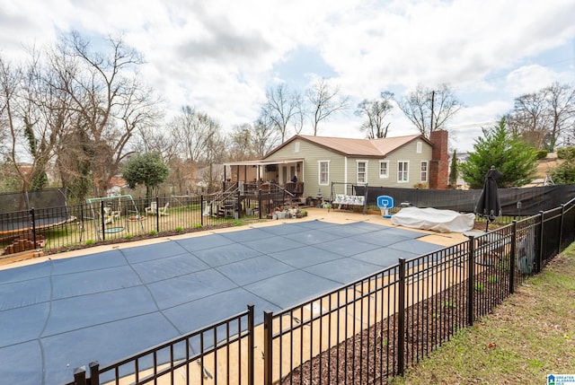 view of swimming pool featuring a patio area, a fenced backyard, a fenced in pool, and a wooden deck