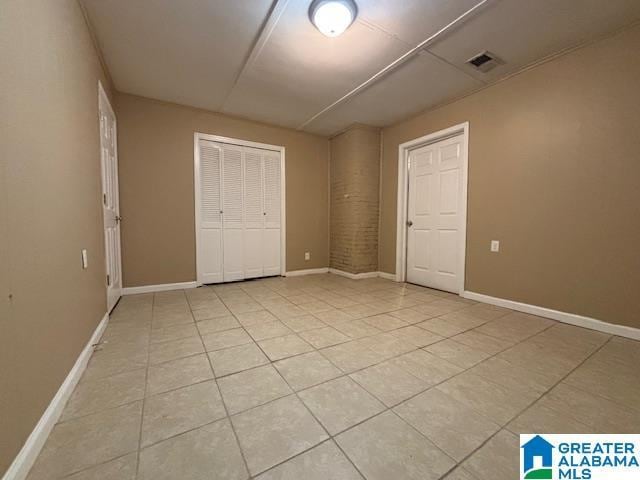 interior space featuring a closet, visible vents, baseboards, and light tile patterned floors