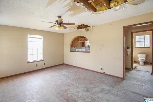 unfurnished room featuring a textured ceiling and baseboards