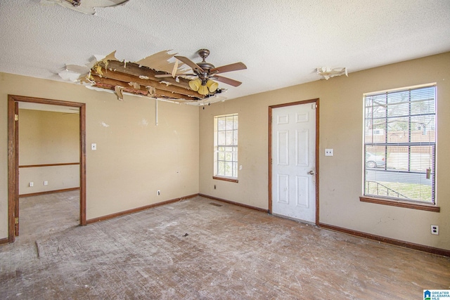 empty room featuring a textured ceiling, ceiling fan, and baseboards