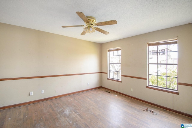 spare room with a wealth of natural light and wood finished floors