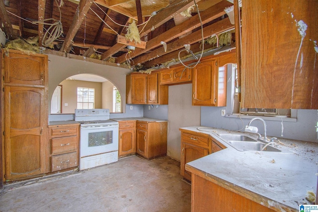 kitchen featuring brown cabinetry, white range with electric stovetop, light countertops, and a sink