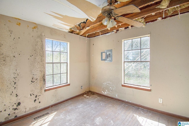 unfurnished room with baseboards, hardwood / wood-style flooring, visible vents, and a ceiling fan