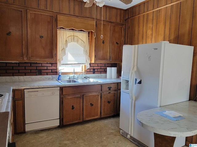 kitchen featuring light countertops, white appliances, brown cabinetry, and a sink