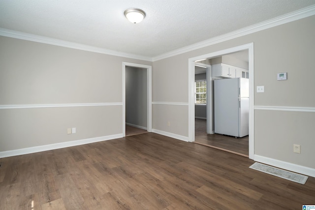 unfurnished room with a textured ceiling, ornamental molding, dark wood finished floors, and baseboards