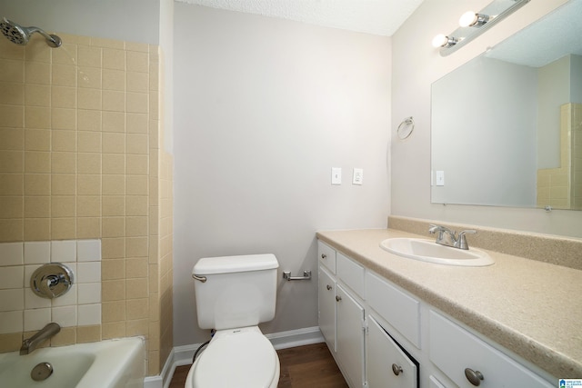 bathroom with shower / bath combination, baseboards, toilet, wood finished floors, and vanity